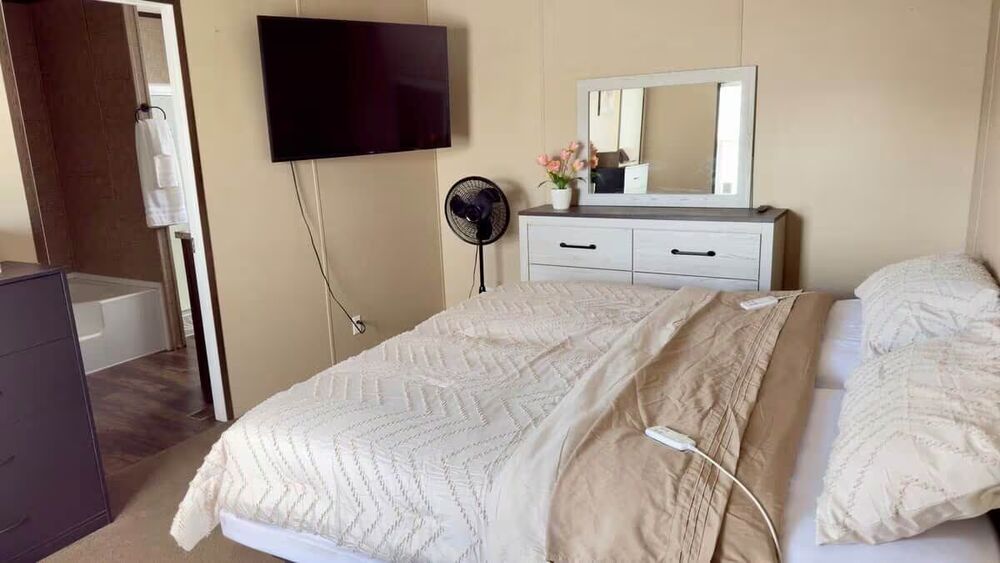 Master bedroom suite with mounted TV and dresser